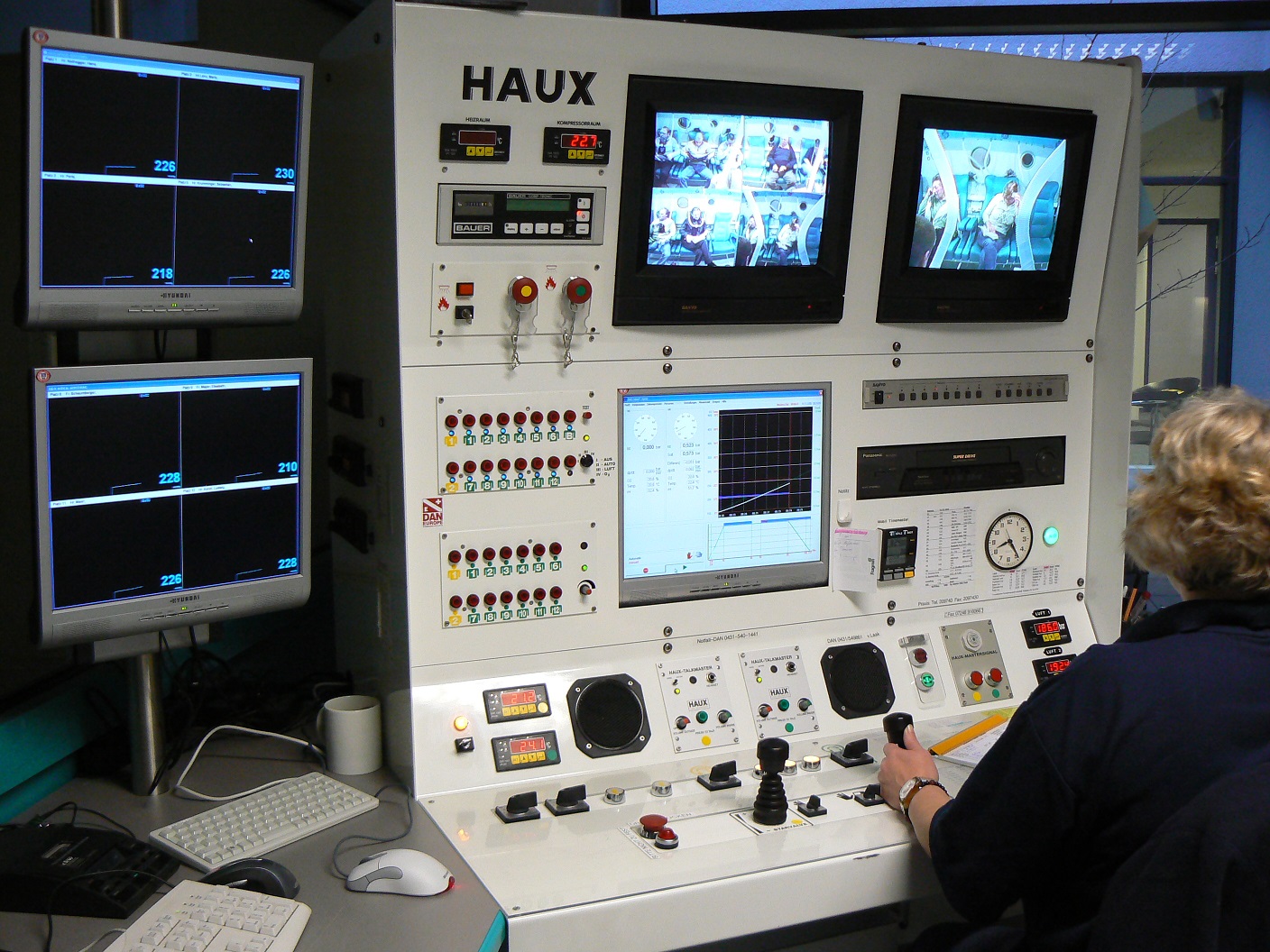 Leitstand einer Mehrplatz-Druckkammer mit Monitoren für die Videoüberwachung der Behandlungsplätze